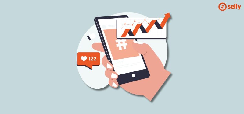 grafika przedstawiająca rękę trzymającą telefon z odpalonymi mediami społecznościowymi. Temat wpisu: kanały dystrybucji